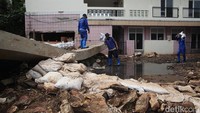 Sejumlah petugas memeriksa kondisi aliran Kali Pulo di sekitar tanggul yang jebol. Pengecekan dilakukan untuk memastikan tidak ada retakan tambahan di sepanjang tanggul.