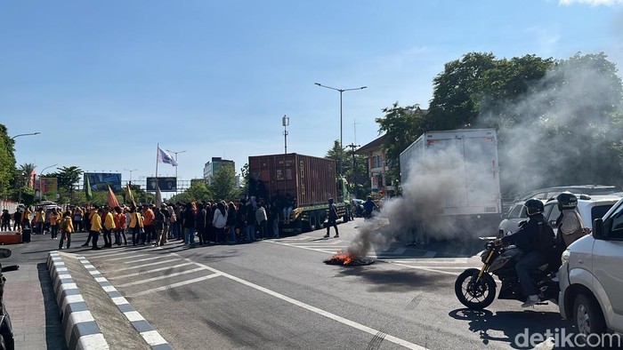 Mahasiswa UNM menggelar demonstrasi di depan menara Pinisi, menyebabkan kemacetan di Jalan AP Pettarani.