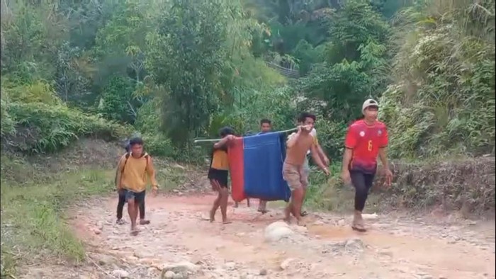 Warga menandu pasangan suami istri yang sakit melewati jalan rusak di Kabupaten Mamasa, Sulawesi Barat (Sulbar).