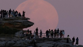 Sementara itu, di Sydney, Australia, supermoon yang sama tampak bersinar terang di atas kawasan North Bondi, memancarkan cahaya keemasan di langit malam. REUTERS/Hollie Adams