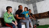 Keluarga Palestina Jaber Dababseh saat duduk bersama anak-anaknya di sebuah gua di Khallit al-Dabe di Masafer Yatta, dekat Hebron, di Tepi Barat yang diduduki oleh Israel. Foto: REUTERS/Mussa Qawasma