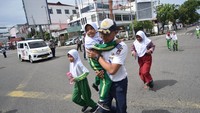 Petugas membantu pelajar berlari ke arah tempat evakuasi sementara saat digelarnya Tsunami Drill di Padang, Sumatera Barat, Rabu (5/11/2025). Latihan mitigasi bencana yang melibatkan ribuan peserta ini bertujuan untuk meningkatkan kewaspadaan dan kemampuan masyarakat dalam menghadapi ancaman gempa dan tsunami, terutama di wilayah-wilayah yang termasuk dalam zona merah. ANTARA FOTO/Iggoy el Fitra