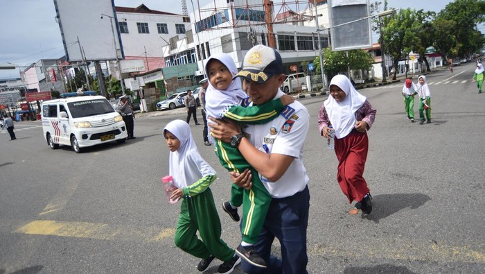 Sejumlah pelajar berlari ke arah tempat evakuasi sementara saat digelarnya Tsunami Drill di Padang, Sumatera Barat, Rabu (5/11/2025). Simulasi mitigasi bencana gempa dan tsunami itu digelar Pemkot Padang di zona merah pada 55 kelurahan sebagai latihan serius menyelamatkan diri dan keluarga jika terjadi bencana sesungguhnya.  ANTARA FOTO/Iggoy el Fitra/tom.