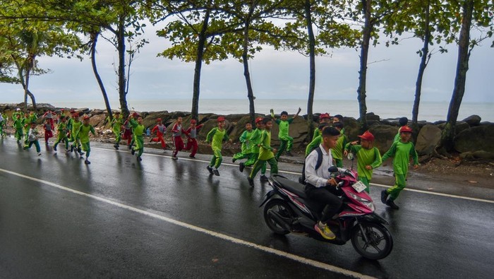 Sejumlah pelajar berlari ke arah tempat evakuasi sementara saat digelarnya Tsunami Drill di Padang, Sumatera Barat, Rabu (5/11/2025). Simulasi mitigasi bencana gempa dan tsunami itu digelar Pemkot Padang di zona merah pada 55 kelurahan sebagai latihan serius menyelamatkan diri dan keluarga jika terjadi bencana sesungguhnya. ANTARA FOTO/Iggoy el Fitra/tom.