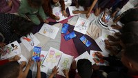 Anak-anak mewarnai gambar selama kegiatan dukungan psikologis. Foto: REUTERS/Ramadan Abed