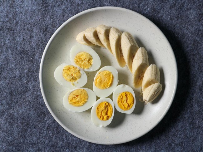 Healthy food. Boiled eggs and sliced bananas on a plate.