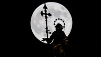 A Beaver Moon supermoon sets behind the Madonnina statue atop Duomo Cathedral, in Milan, Italy, November 5, 2025. REUTERS/Fabrizio Bensch