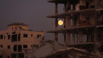 Supermoon “Beaver Moon” tampak di atas bangunan yang hancur di Gaza City saat gencatan senjata berlangsung, Rabu (5/11/2025). Kontras pemandangan bulan terang dan reruntuhan menjadi sorotan global. REUTERS/Dawoud Abu Alkas