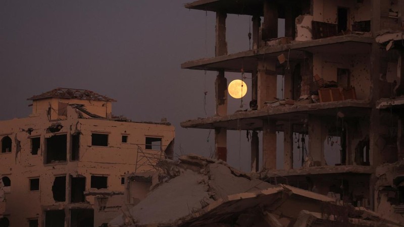 The Beaver Moon supermoon rises above destroyed buildings amid a ceasefire between Israel and Hamas, in Gaza City, November 5, 2025. REUTERS/Dawoud Abu Alkas