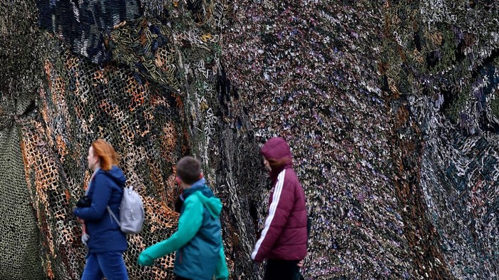 A cyclist rides his bike in front of the artwork 