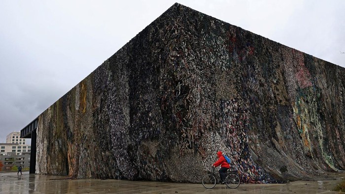 A cyclist rides his bike in front of the artwork 
