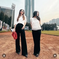 Nia Ramadhani dan putrinya tampil dengan gaya monokrom minimalis yang elegan dan modern. Keduanya mengenakan perpaduan klasik hitam-putih. Nia memilih kemeja putih oversized yang dimasukkan ke dalam celana panjang hitam berpotongan wide-leg, dan Mikka tampil dengan blouse putih renda berpotongan sleeveless yang dipadu dengan celana panjang serupa sang ibu. Foto: Dok. Instagram
