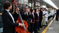 Musisi tampil di depan rangkaian kereta mewah Orient Express La Dolce Vita, sementara awak bersiap di peron sebelum keberangkatan dari Roma, Italia. Kereta ini menandai kembalinya perjalanan rel premium bergaya nostalgia Italia dengan layanan ultra-mewah. REUTERS/Yara Nardi