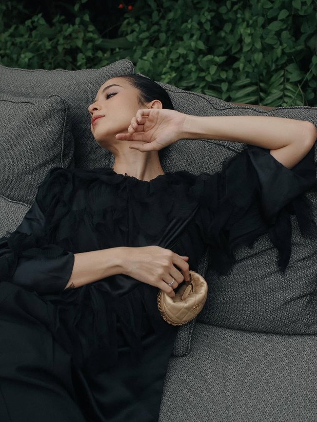 Sementara itu, Laura memilih dress hitam yang dikontraskan dengan tas mungil Chanel berwarna emas. (Foto: Instagram/@putrimarino)