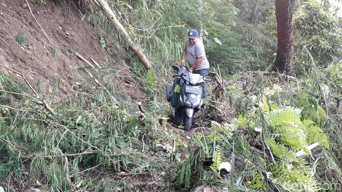 Sejumlah warga nekat menerobos longsor di Banjar Wanakeling, Sulangai, Badung, Bali, Kamis (6/11/2025). (Foto: Agus Eka/detikBali)
