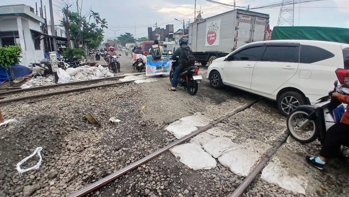 Suasana kendaraan melintas di geometri jalan rel di perlintasan kereta api Jalan Kaligawe Raya, Kota Semarang.