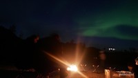 Suasana api unggun di bawah cahaya aurora