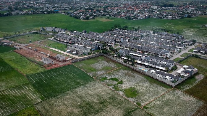 Foto udara kompleks perumahan di antara area persawahan di Sepatan, Kabupaten Tangerang, Banten, Kamis (6/11/2025). Presiden Prabowo Subianto mengatakan pemerintah mulai mencetak sawah baru seluas 225.000 hektare dan menargetkan total perluasan mencapai 480.000 hektare pada akhir tahun 2026 guna mengatasi sekitar 100.000 hektare lahan sawah di Indonesia yang hilang setiap tahunnya akibat alih fungsi menjadi kawasan perumahan, industri dan peruntukan lain. ANTARA FOTO/Putra M. Akbar/foc.