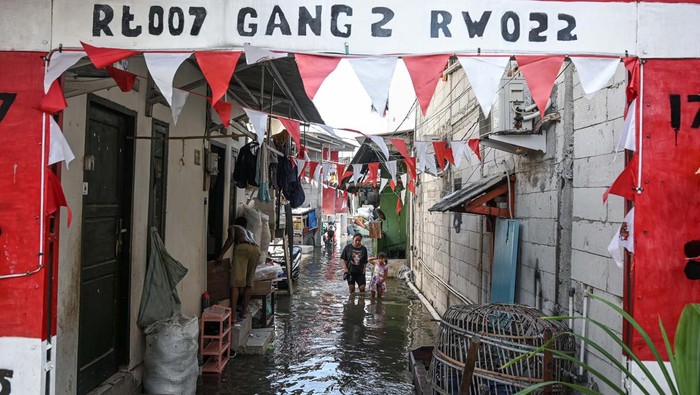 Warga beristirahat di dalam rumah makan saat banjir rob di kawasan Muara Angke, Jakarta, Jumat (7/11/2025). Badan Meteorologi, Klimatologi, dan Geofisika (BMKG) memperkirakan potensi banjir rob akan terjadi di sejumlah wilayah pesisir hingga 12 November 2025 yang disebabkan posisi bulan berada lebih dekat dari jarak rata-ratanya dengan Bumi pada November sehingga berpotensi meningkatkan tinggi pasang air laut secara signifikan. ANTARA FOTO/Sulthony Hasanuddin