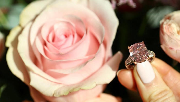 A staff member wears the Glowing Rose, a 10.08-carat cushion brilliant-cut fancy vivid pink diamond, which could fetch US$20 million during an auction preview for Sotheby’s in Geneva, Switzerland, November 6, 2025. REUTERS/Denis Balibouse