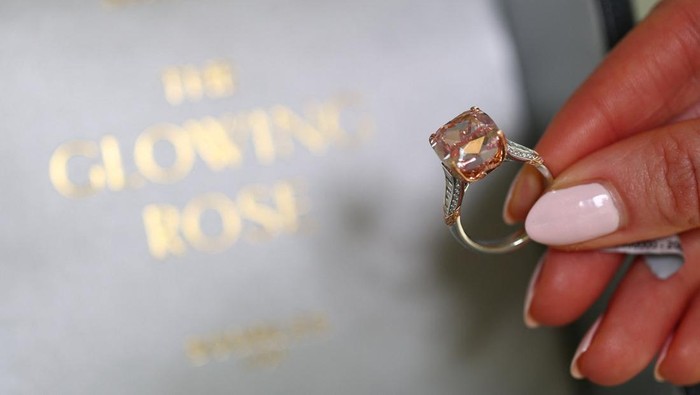 A staff member wears the Glowing Rose, a 10.08-carat cushion brilliant-cut fancy vivid pink diamond, which could fetch US$20 million during an auction preview for Sotheby’s in Geneva, Switzerland, November 6, 2025. REUTERS/Denis Balibouse