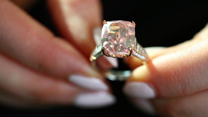 A staff member wears the Glowing Rose, a 10.08-carat cushion brilliant-cut fancy vivid pink diamond, which could fetch US$20 million during an auction preview for Sotheby’s in Geneva, Switzerland, November 6, 2025. REUTERS/Denis Balibouse