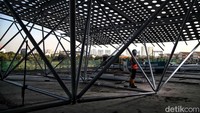 Pekerja membangun sebuah rangka konstruksi dengan bahan dasar alumunium. 