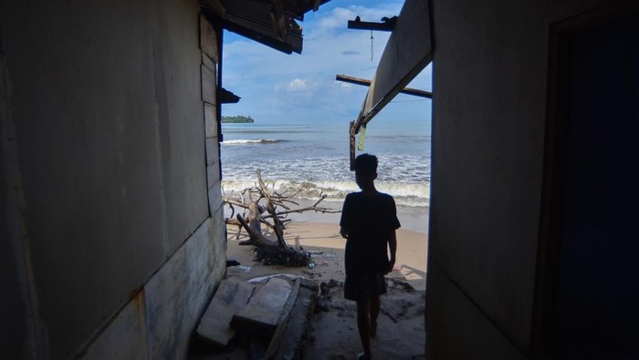 Warga berada di dalam rumahnya yang jebol akibat gelombang pasang di Pantai Air Manis, Padang, Sumatera Barat, Jumat (7/11/2025). Gelombang pasang yang terjadi sejak tiga hari terakhir mengakibatkan sejumlah rumah di kelurahan tepi pantai tersebut rusak sehingga warga terpaksa mengungsi ke tempat sanak saudaranya saat malam hari. ANTARA FOTO/Iggoy el Fitra/bar