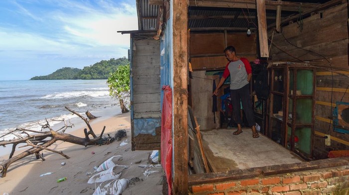 Warga berada di dalam rumahnya yang jebol akibat gelombang pasang di Pantai Air Manis, Padang, Sumatera Barat, Jumat (7/11/2025). Gelombang pasang yang terjadi sejak tiga hari terakhir mengakibatkan sejumlah rumah di kelurahan tepi pantai tersebut rusak sehingga warga terpaksa mengungsi ke tempat sanak saudaranya saat malam hari. ANTARA FOTO/Iggoy el Fitra/bar