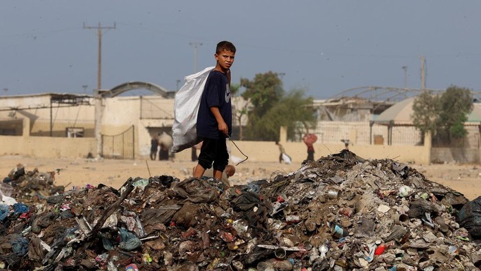 Kondisi lingkungan di Gaza kian memprihatinkan. Di kota Khan Younis, tumpukan sampah dan limbah rumah tangga kini memenuhi jalanan serta area pengungsian di tengah reruntuhan bangunan yang hancur akibat konflik berkepanjangan. REUTERS/Ramadan Abed