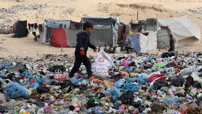 Kondisi lingkungan di Gaza kian memprihatinkan. Di kota Khan Younis, tumpukan sampah dan limbah rumah tangga kini memenuhi jalanan serta area pengungsian di tengah reruntuhan bangunan yang hancur akibat konflik berkepanjangan. REUTERS/Ramadan Abed