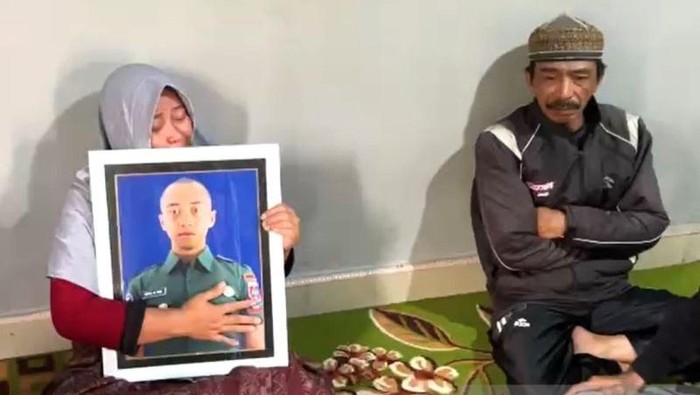 Orang tua memegang foto anaknya Prajurit Dua (Prada) HMN di rumah duka yang dinyatakan meninggal dunia diduga dianiaya seniornya pada tempatnya bertugas di C Yonarhanud 4/AAY, Kabupaten Gowa, Sulawesi Selatan.  (ANTARA/Darwin Fatir)