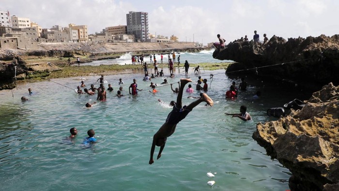 A reveller jumps through the air as he plays at the beach near the Indian Ocean waters in Hamarweyne district of Mogadishu, Somalia November 6, 2025. REUTERS/Feisal Omar