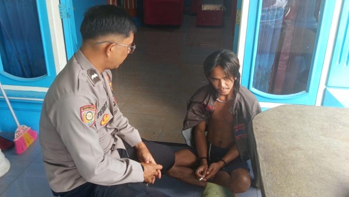 Pelaku saat diamankan polisi usai menganiaya ayahnya