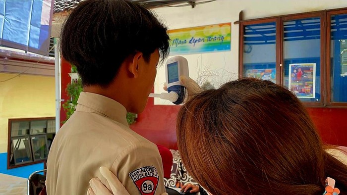 Petugas Dinas Kesehatan Kota Batu melakukan skrinning kepada seorang siswa