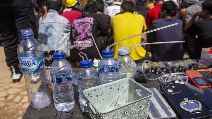 Petugas kepolisian dan Badan Narkotika Nasional (BNN) mengamankan seorang warga yang berusaha kabur saat razia gabungan di Kampung Madani Bersih Narkoba (Bersinar), Muka Kuning, Batam, Kepulauan Riau, Jumat (7/11/2025). Dalam razia gabungan BNNP Kepri bersama Polri, TNI, dan Satpol PP tersebut berhasil mengamankan 36 orang warga yang positif mengkonsumsi narkotika setelah dilakukan tes urine. ANTARA FOTO/Teguh Prihatna/bar