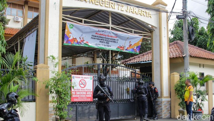 Anggota Brimob menjaga kawasan SMA Negeri 72 Kelapa Gading setelah terjadi ledakan, Jumat (7/11/2025).  Ledakan diduga bersumber dari speaker di area masjid sekolah.