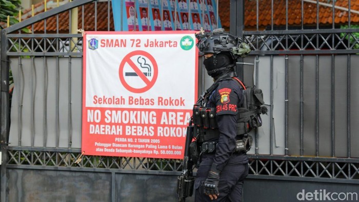 Anggota Brimob menjaga kawasan SMA Negeri 72 Kelapa Gading setelah terjadi ledakan, Jumat (7/11/2025).  Ledakan diduga bersumber dari speaker di area masjid sekolah.