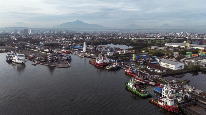 Nelayan menggunakan perahunya melintas di dekat bongkar muat peti kemas di Terminal Peti Kemas Pelabuhan Tanjung Emas, Semarang, Jawa Tengah, Jumat (7/11/2025). Menteri Koordinator Bidang Infrastruktur dan Pembangunan Kewilayahan, Agus Harimurti Yudh
