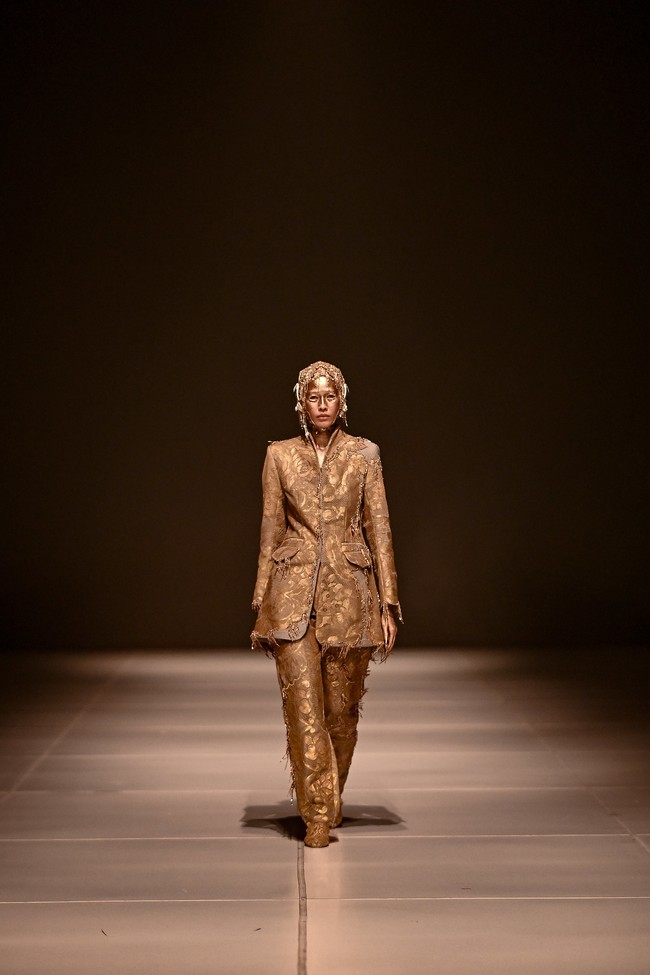Riasan wajah menjadi statement tersendiri. Pulasan berwarna emas dipadu headpiece senada yang mencakup bentukan baru dari suntiang atau pelindung kepala bergaya etnik semakin mempertegas bahwa koleksi ini pantas disebut sebagai wearable-art. (Foto: Dok. JFW)
