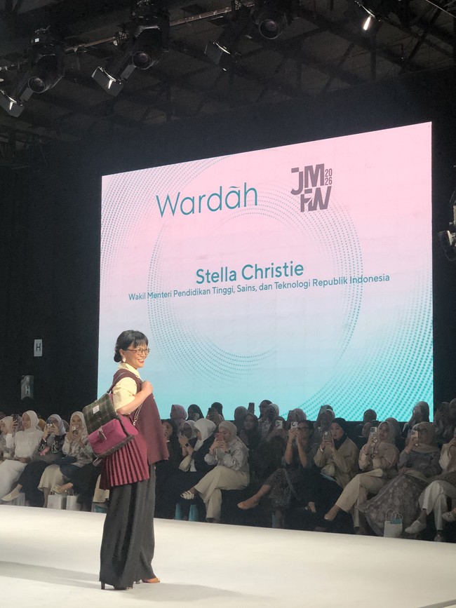 Stella Christie, Wakil Menteri Pendidikan Tinggi, Sains, dan Teknologi Republik Indonesia jadi model catwalk mengenakan outer berwarna butter yellow dengan vest panjang tanpa lengan berwarna merah marun. Vest tersebut tampak asimetris atau memiliki detail lipatan di bagian pinggang. Foto: Gresnia/Wolipop.