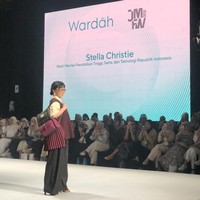 Stella Christie, Wakil Menteri Pendidikan Tinggi, Sains, dan Teknologi Republik Indonesia jadi model catwalk mengenakan outer berwarna butter yellow dengan vest panjang tanpa lengan berwarna merah marun. Vest tersebut tampak asimetris atau memiliki detail lipatan di bagian pinggang. Foto: Gresnia/Wolipop.