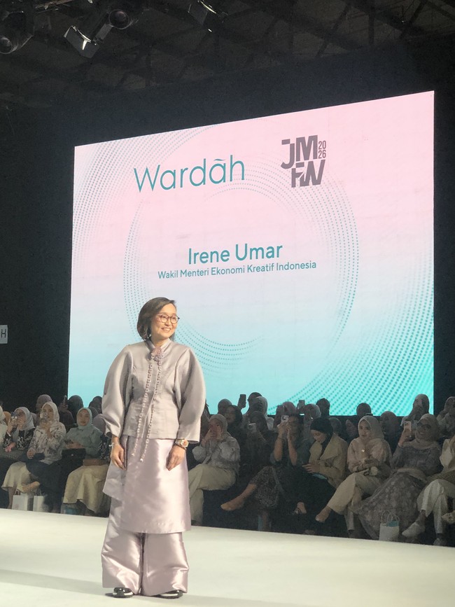 Irene Umar, Wakil Menteri Ekonomi Kreatif Indonesia catwalk memakai setelan longgar berwarna lilac yang terlihat mewah. Atasan berlengan panjang dengan detail kerah tinggi dan sulaman atau tekstur yang elegan, dipadukan dengan wide-leg pants dengan warna senada. Tampilannya terkesan elegan, formal, dan modern. Foto: Gresnia/Wolipop.