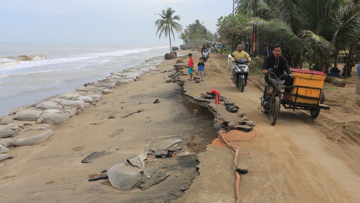 Foto udara kondisi badan jalan yang amblas tergerus abrasi pantai di Desa Lhok Puuk, Seunudon, Aceh Utara, Aceh, Sabtu (8/11/2025). Abrasi pantai akibat air pasang dan gelombang tinggi yang terjadi sejak Rabu (5/11/2025) merusak garis pantai dan ruas jalan lintas antardesa sepanjang 1,5 kilometer, serta mengancam ratusan rumah warga. ANTARA FOTO/Syifa Yulinnas/rwa.