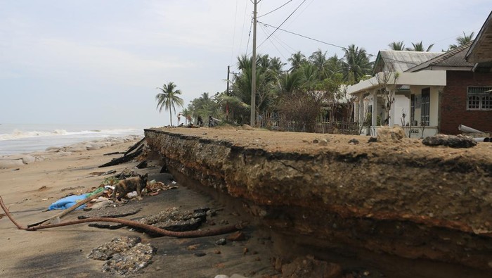 Foto udara kondisi badan jalan yang amblas tergerus abrasi pantai di Desa Lhok Puuk, Seunudon, Aceh Utara, Aceh, Sabtu (8/11/2025). Abrasi pantai akibat air pasang dan gelombang tinggi yang terjadi sejak Rabu (5/11/2025) merusak garis pantai dan ruas jalan lintas antardesa sepanjang 1,5 kilometer, serta mengancam ratusan rumah warga. ANTARA FOTO/Syifa Yulinnas/rwa.