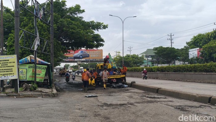 Terlihat belasan orang menggunakan baju oranye sedang memperbaiki jalan di depan SPBU 44.501.36 Kaligawe, Semarang, Sabtu (8/11/2025).