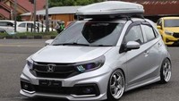 Mobil modifikasi fungsional ini dirasa sangat cantik untuk bisa berjalan di jalanan. Honda Brio asal Padang tampil penuh modifikasi dengan kombinasi gaya sporty dan stance. Tampilan depan menggunakan headlamp custom Brio facelift Biled Vahid E.10 + RGB, ditambah foglamp mini laser, bumper Mobilio RS, hingga air suspension Airgen agar ground clearance dapat diatur sesuai kebutuhan show. Foto: dok. Honda Prospect Motor