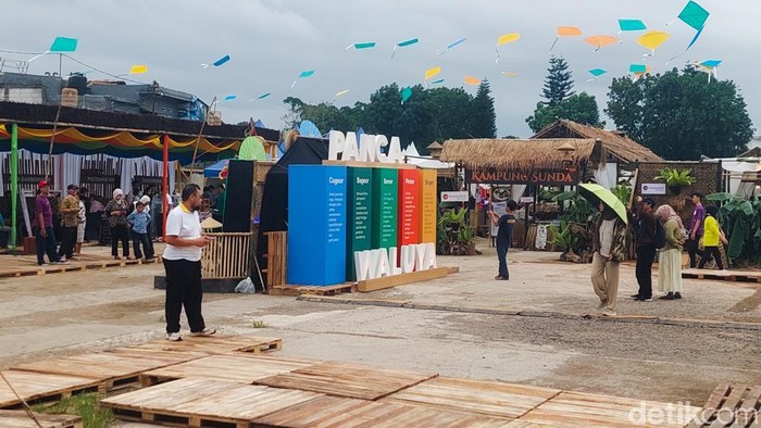 Pengunjung berpayung nikmati suasana West Java Festival yang diwarnai gerimis