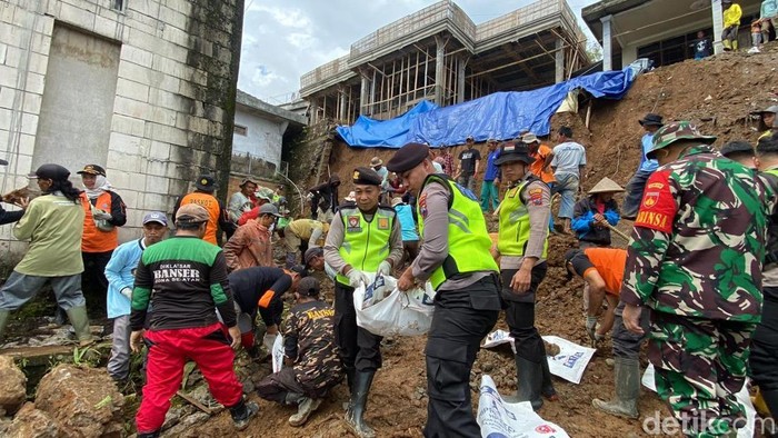 Personel Polsek Bulu dan Dalmas Polres Temanggung bersama warga saat membersihkan material longsor di Dusun Grubug, Desa Wonotirto, Kecamatan Bulu, Sabtu (8/11/2025).