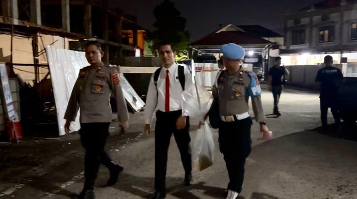 Polisi menenteng barang bukti gagang sapu yang digunakan Bripda Waldi untuk habisi dosen EY